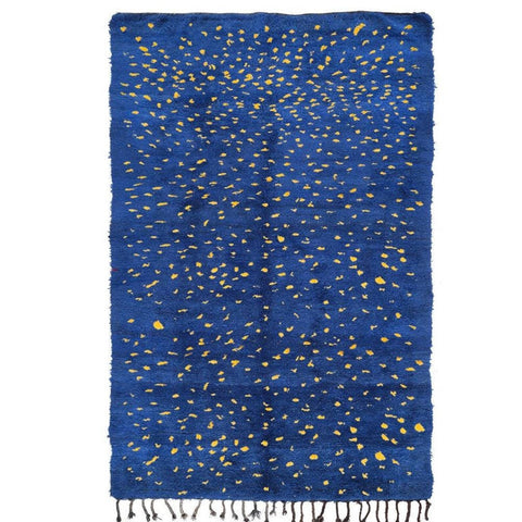 Front view of a blue Moroccan rug featuring fringe edges on a white background.