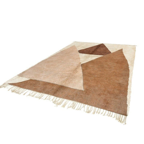 Lifestyle shot of the abstract Moroccan rug in caramel and cream with fringe edges.