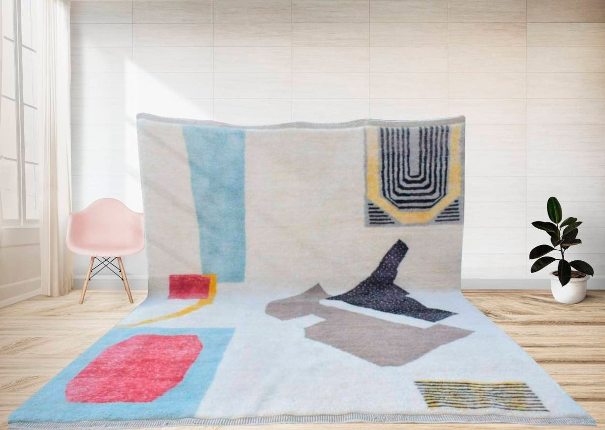 Lifestyle shot of a large black geometric Moroccan rug featuring an abstract design with blue, red, and yellow colors.