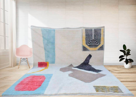 Lifestyle shot of a large black geometric Moroccan rug featuring an abstract design with blue, red, and yellow colors.