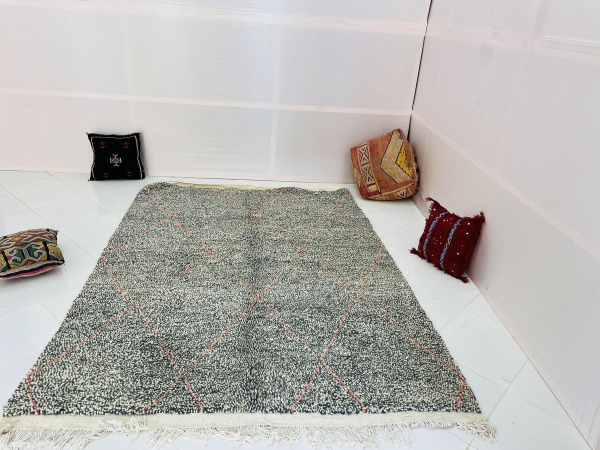 Lifestyle view of a gray geometric Beni Ourain Moroccan rug featuring abstract designs in blue and red.