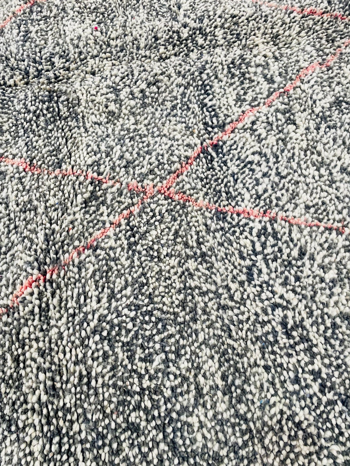 Close-up of the textured surface of a gray geometric Beni Ourain Moroccan rug featuring a geometric design.