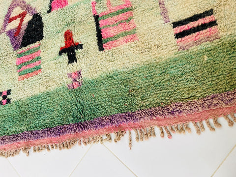 Close-up view of the textured fibers on a Moroccan rug displaying colorful patterns.