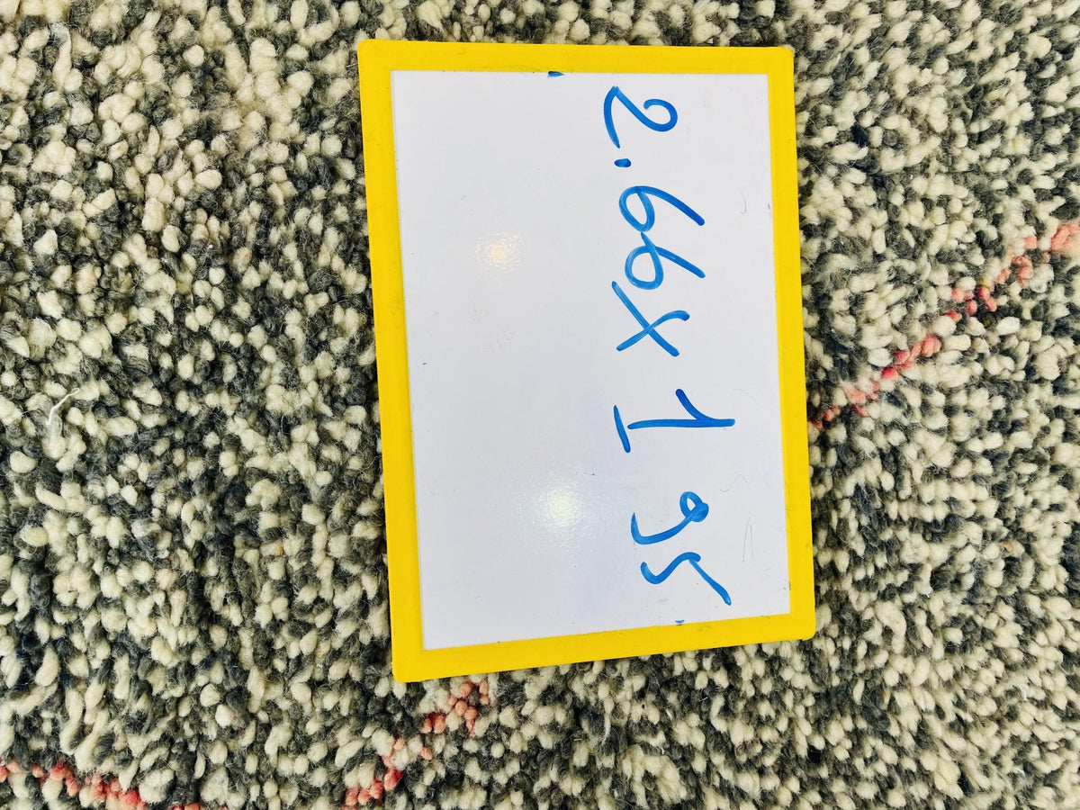 Detail shot of the label on a gray geometric Beni Ourain Moroccan rug displaying dimensions and text.