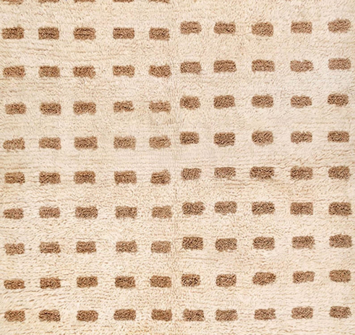 Close-up detail of the warm beige Beni Ourain rug highlighting its geometric pattern.