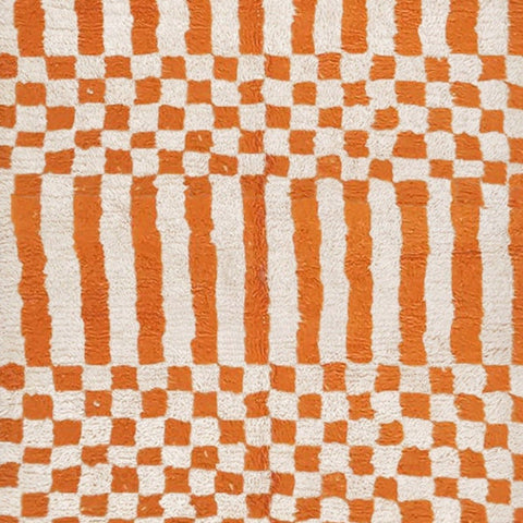 Close-up detail of the orange Moroccan rug showcasing a checkerboard pattern.