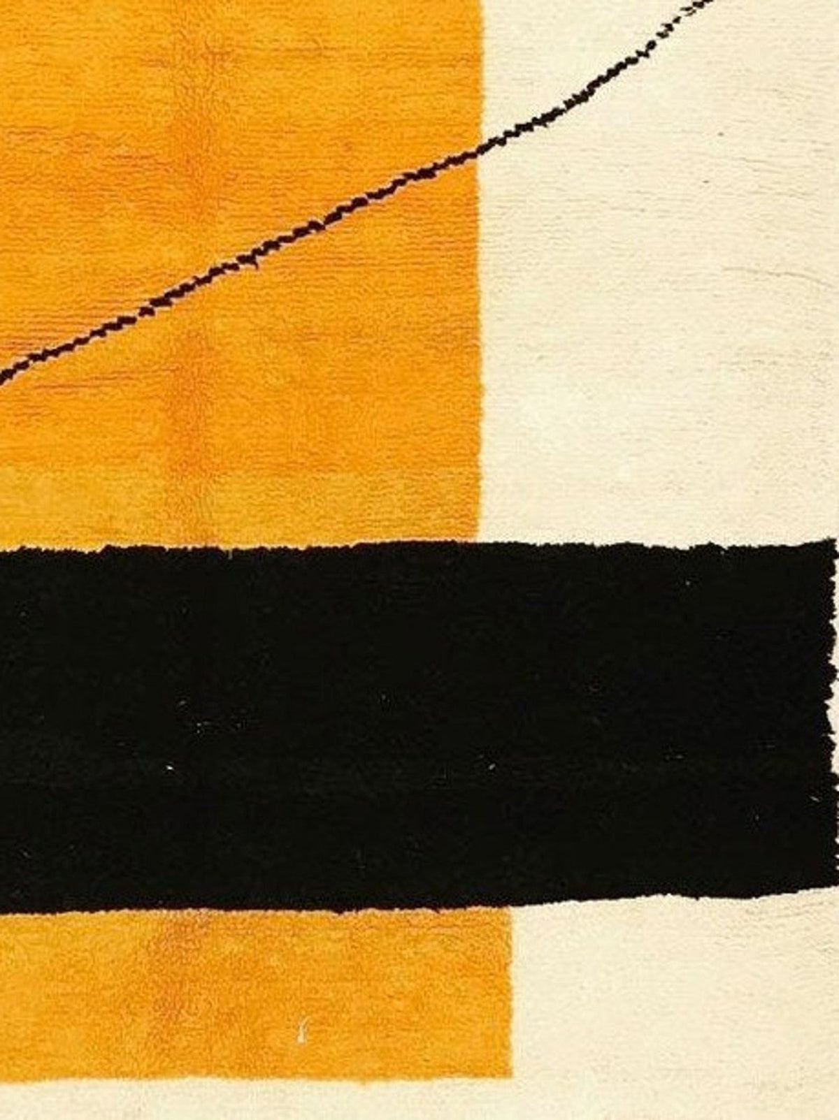 Close-up detail of the geometric pattern in orange, cream, and black on the rug.