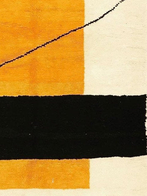 Close-up detail of the geometric pattern in orange, cream, and black on the rug.