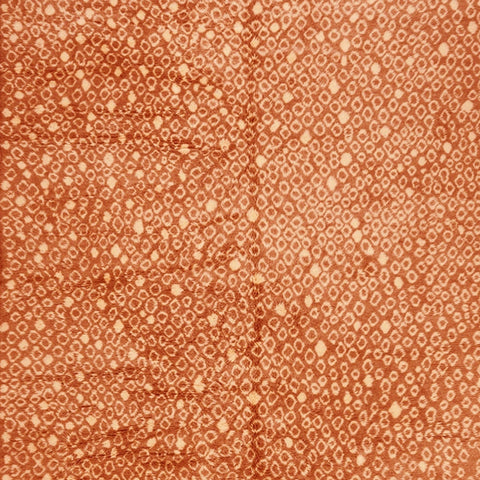 Close-up detail of the orange Moroccan rug showcasing its soft texture and earthy design.