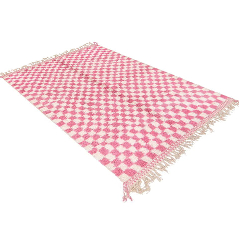 View of the pink checkered Beni Ourain rug featuring an abstract design and fringed edges.
