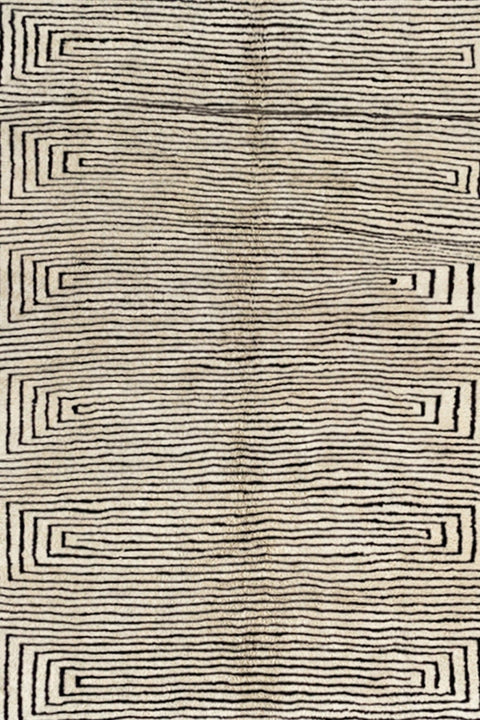 Close-up detail of the textured surface of the gray geometric Moroccan rug featuring a spiral black design.