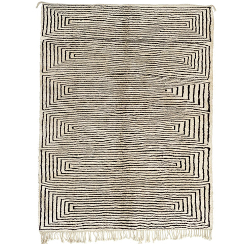 Front view of the gray geometric Moroccan rug with a spiral black design and fringed edges.