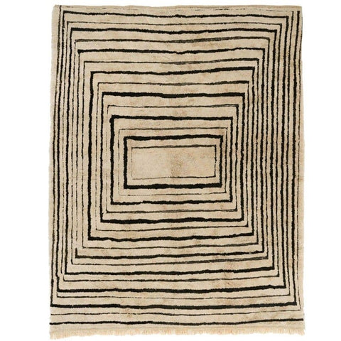 Detail close-up of taupe and black spiral design on a rectangular Moroccan rug.
