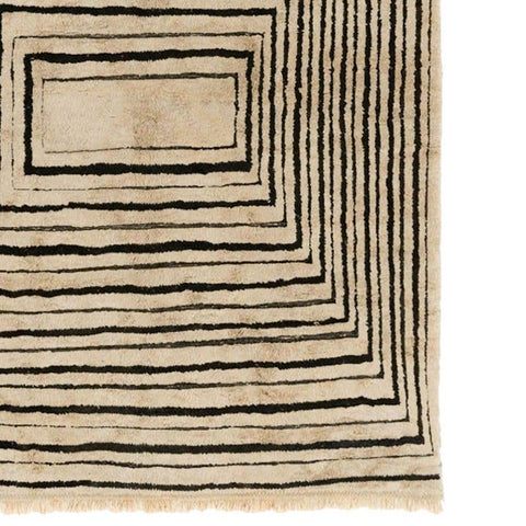 Detail close-up showcasing the taupe and black spiral pattern on the rug.