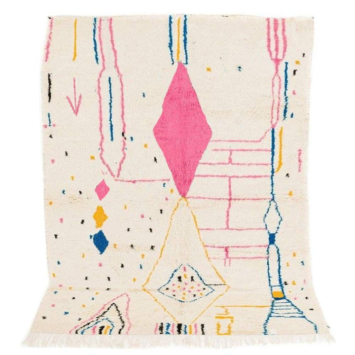 Detail close-up of a colorful Moroccan rug featuring tribal patterns in pink, blue, and cream.