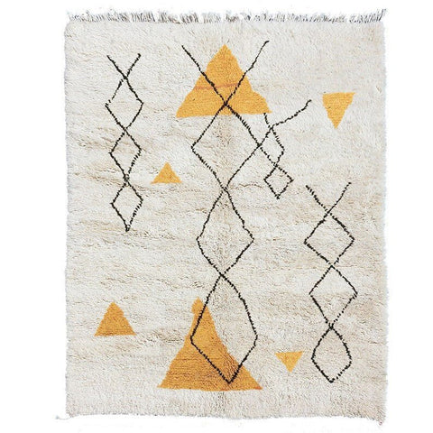 Detail view of the yellow and black geometric pattern on the Moroccan rug.