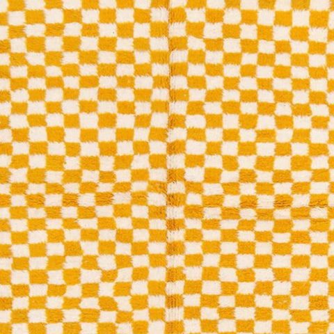 Detail close-up of the yellow checkered rug showcasing its soft texture.