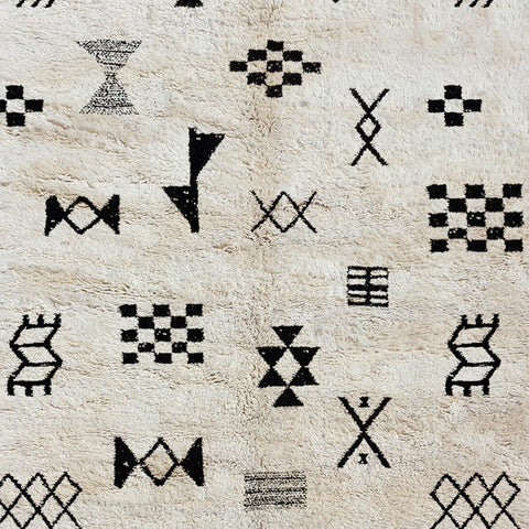 Detail close-up of a black and white Moroccan Tribal Custom Rug highlighting tribal patterns on a solid background.