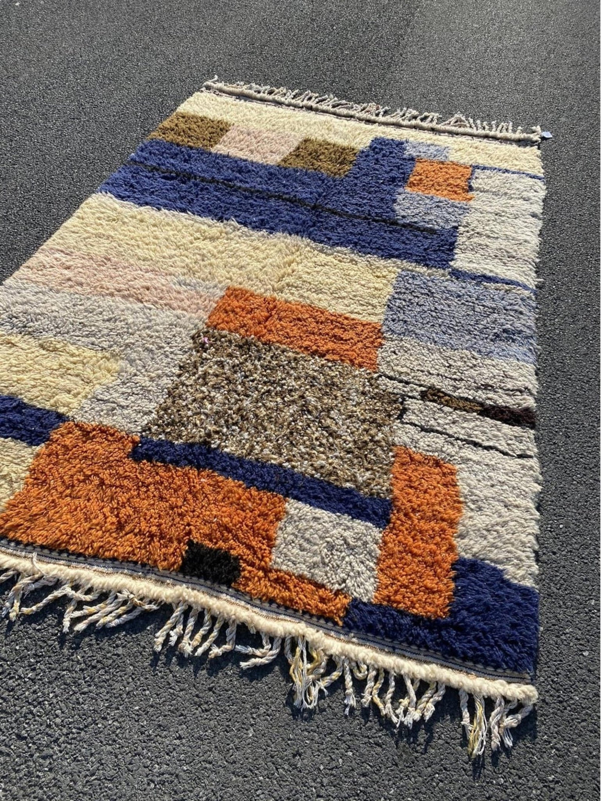Front view of a multicolor geometric Boujaad Moroccan rug featuring orange, blue, cream, and brown with fringe edges.