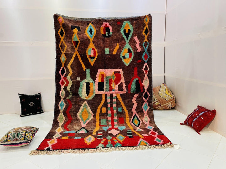 Lifestyle shot of a multicolored Moroccan rug featuring geometric patterns on a white background.
