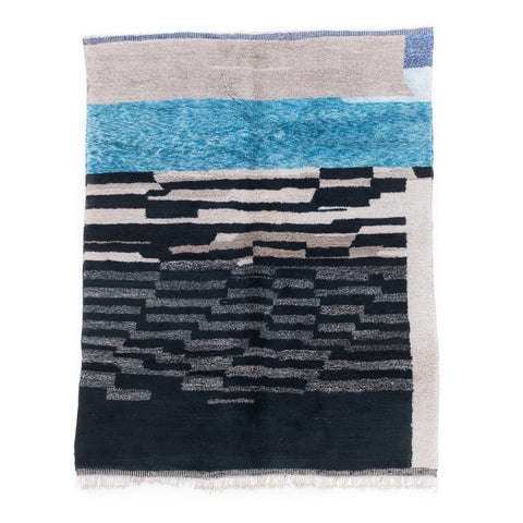 Detail shot of blue and charcoal color block area rug with striped pattern.