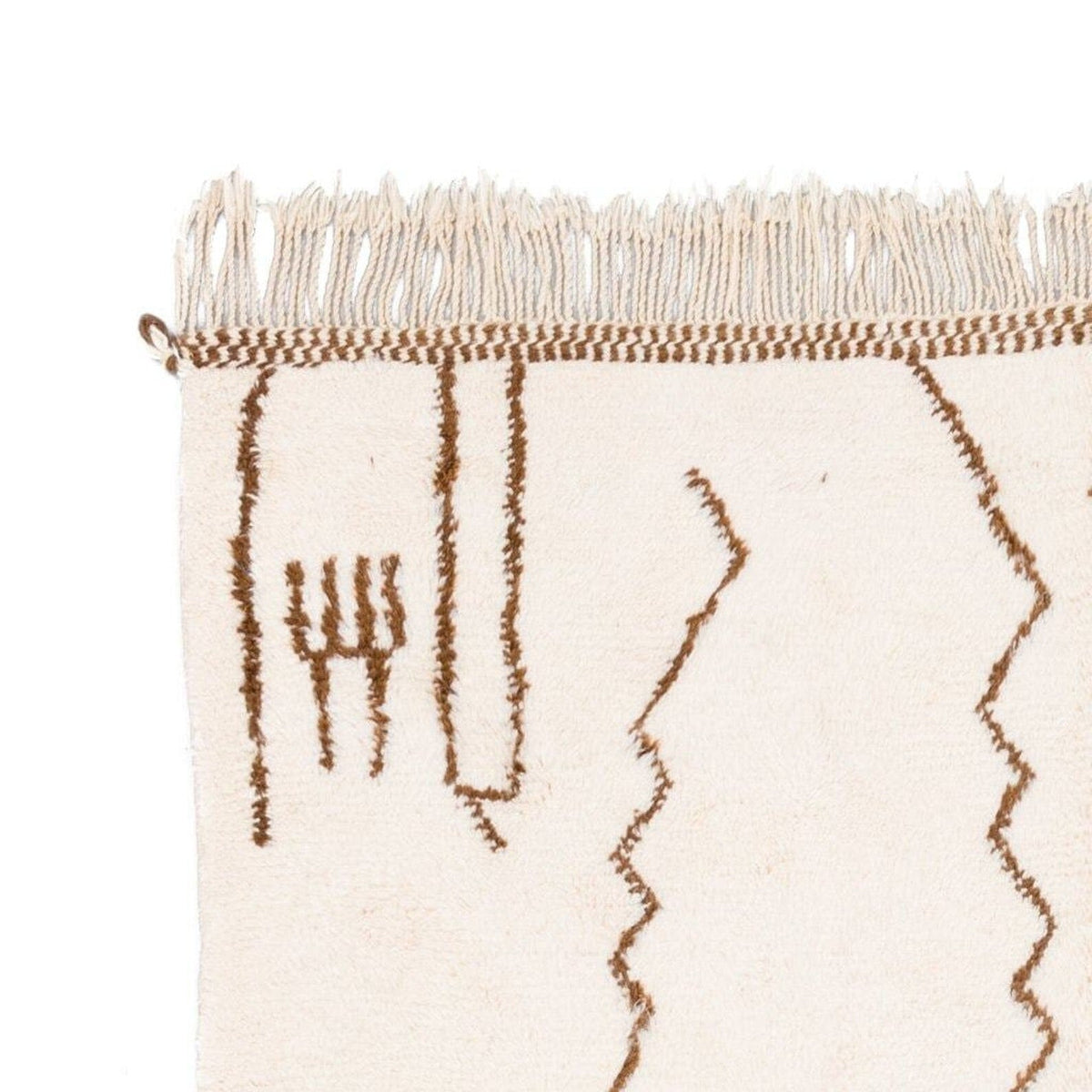 Close-up detail of the off-white rug featuring fringe detail and an abstract pattern.