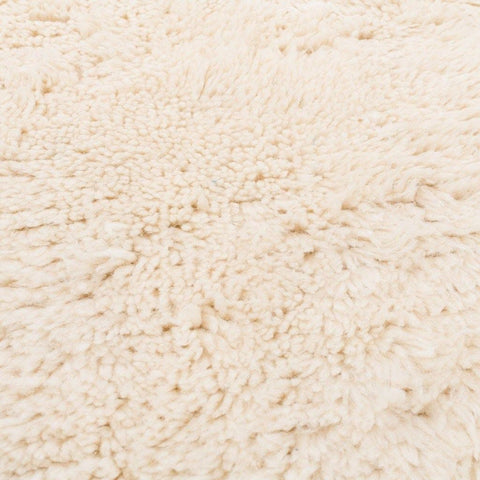 Close-up detail of the off-white area rug showcasing its abstract design.