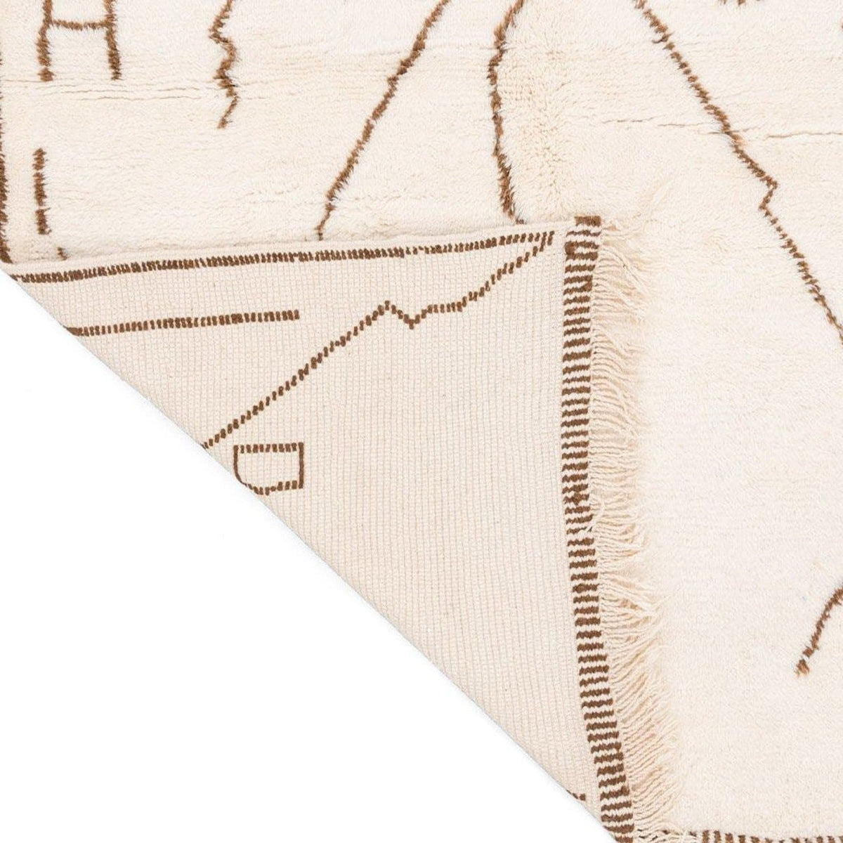 Close-up detail of the off-white rug with a zigzag pattern and soft texture.