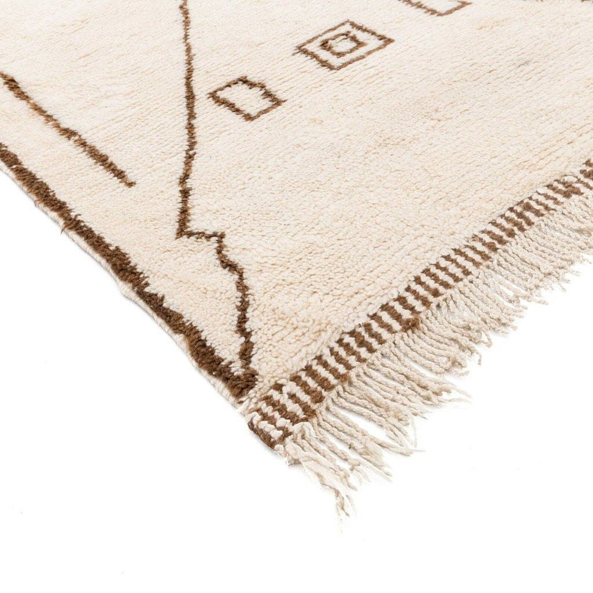 Close-up detail of the off-white rug showing fringe detail and a textured edge.