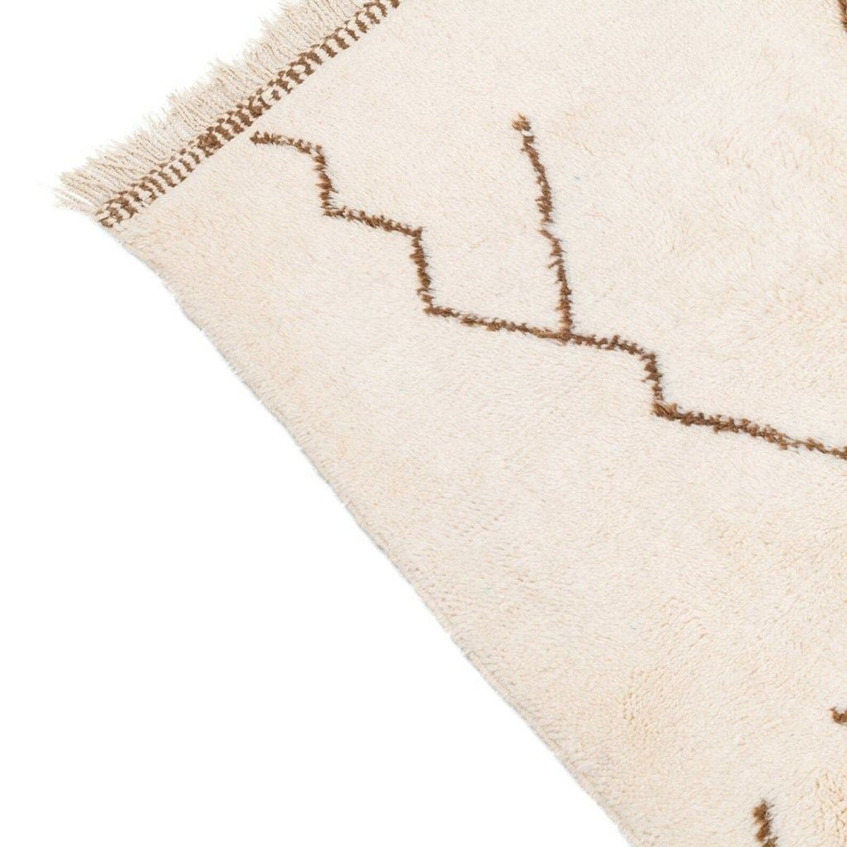 Close-up detail of the off-white area rug with a textured surface and zigzag patterns.
