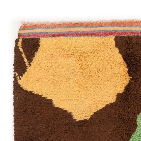 Detail of the orange and brown rug featuring an abstract pattern on a white background.