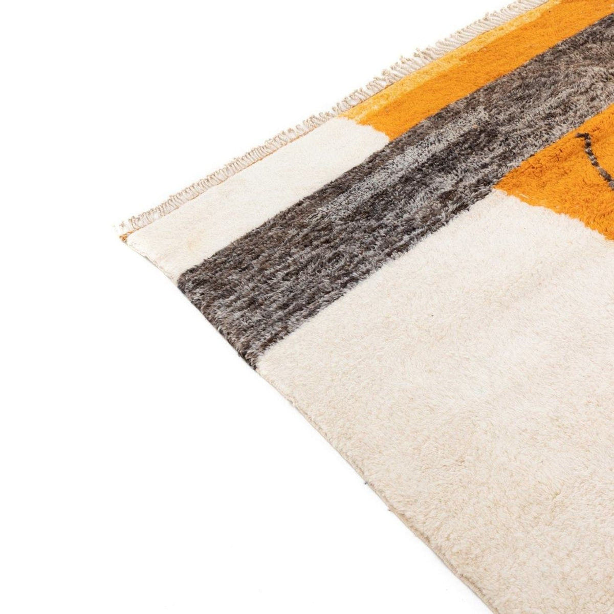 Edge view of the orange tribal rug showing color block and woven texture.