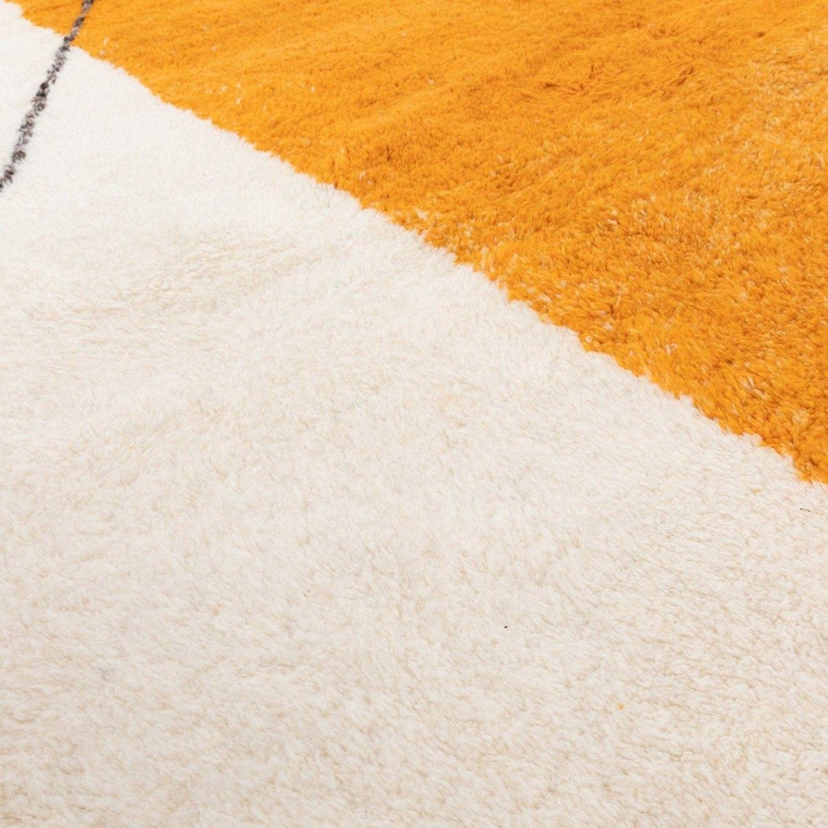Detail view of the abstract pattern on the orange tribal rug.