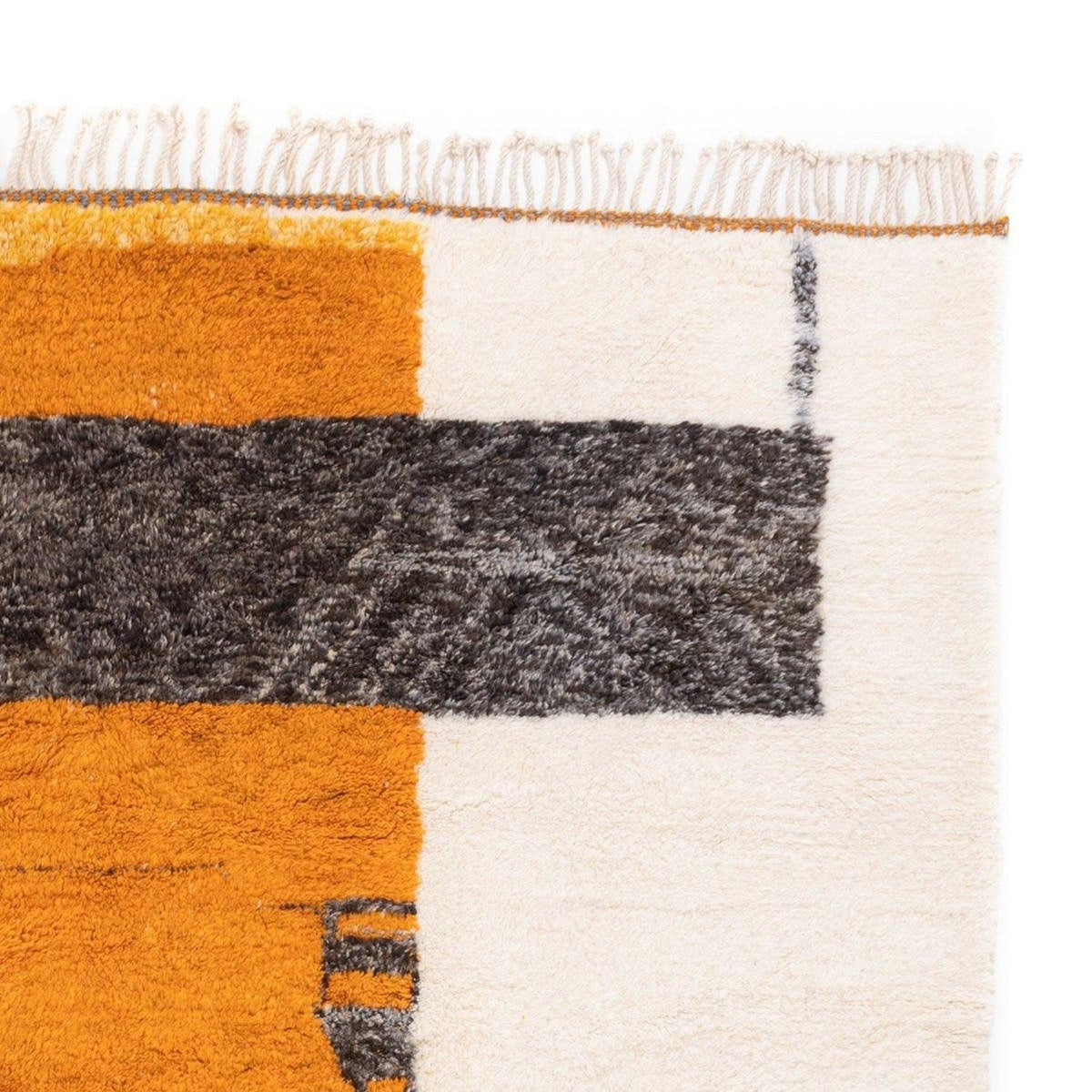 Detail close-up of the abstract pattern and thick pile on the orange tribal rug.