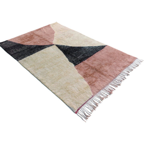 Front view of the pink Moroccan rug highlighting its geometric features and fringe edges on a white background.