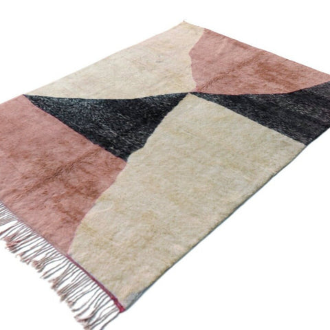 Front view of the pink Moroccan rug showcasing geometric designs and fringe edges against a white backdrop.