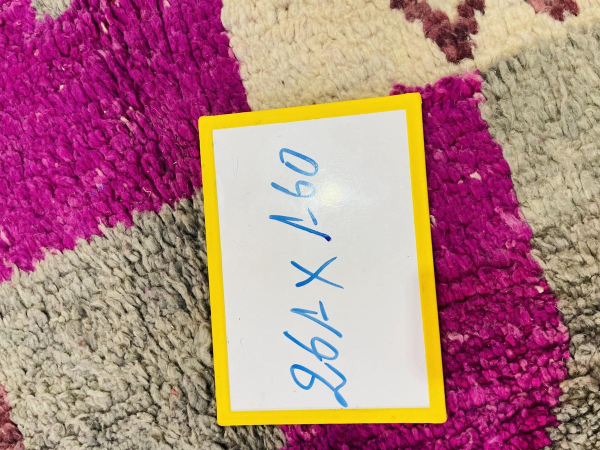 Detail shot showing size information on a vintage Moroccan rug with a simple design.