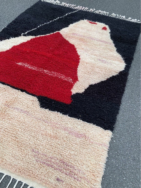 Lifestyle shot of the red and black rug featuring an artistic pattern and decorative use.
