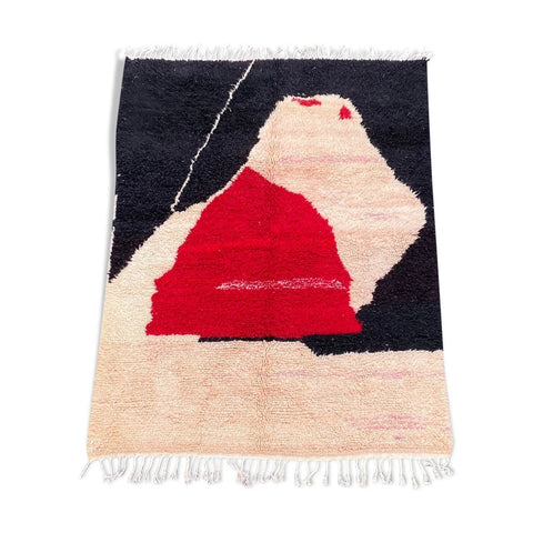 Detail close-up of the red and black geometric pattern on the Beni Ourain rug.