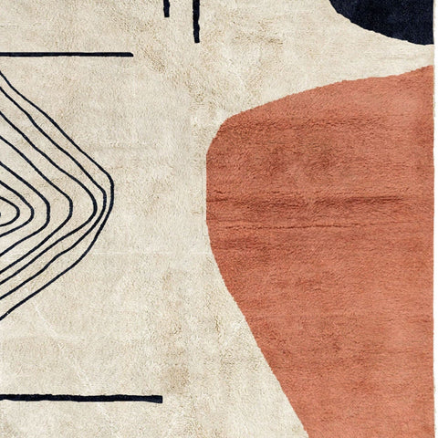 Close-up detail of the coral and cream abstract Moroccan rug showcasing its geometric patterns.