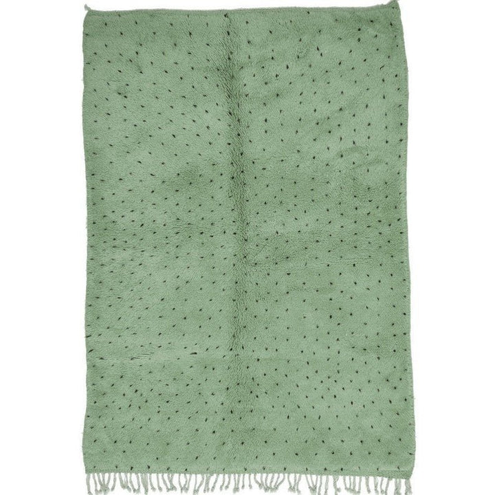 Detail close-up of sage green rug featuring white dots.