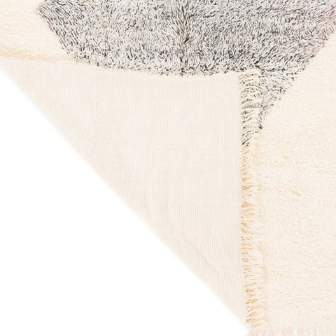 Detail view of the rug's underside showcasing the backing material and stitching.