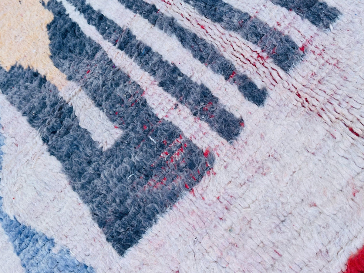 Close-up of the striped design on the Moroccan rug featuring blue, white, and red colors.
