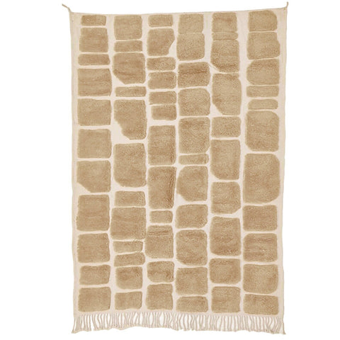 Lifestyle shot of a textured Moroccan rug in a natural setting, highlighting its geometric design.