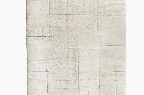 Detail close-up of an off-white textured Beni Ourain Moroccan rug on a white background.