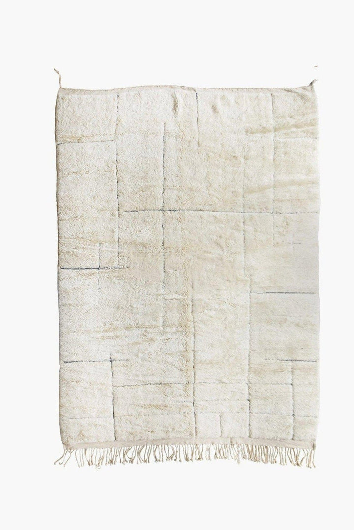 Detail close-up of an off-white textured Beni Ourain Moroccan rug on a white background.