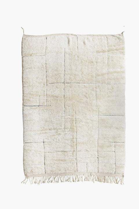 Detail close-up of an off-white textured Beni Ourain Moroccan rug on a white background.