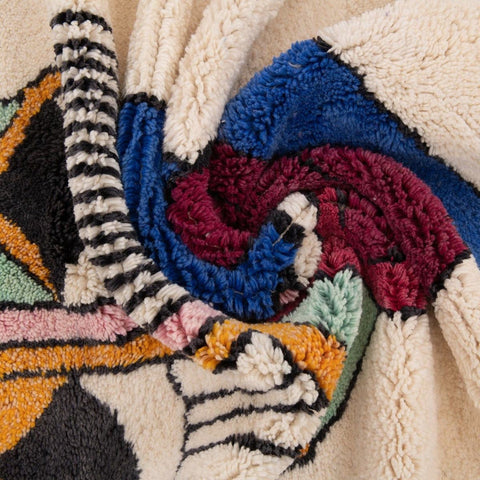 Detail of the artsy face rug featuring a simple edge and thick pile.