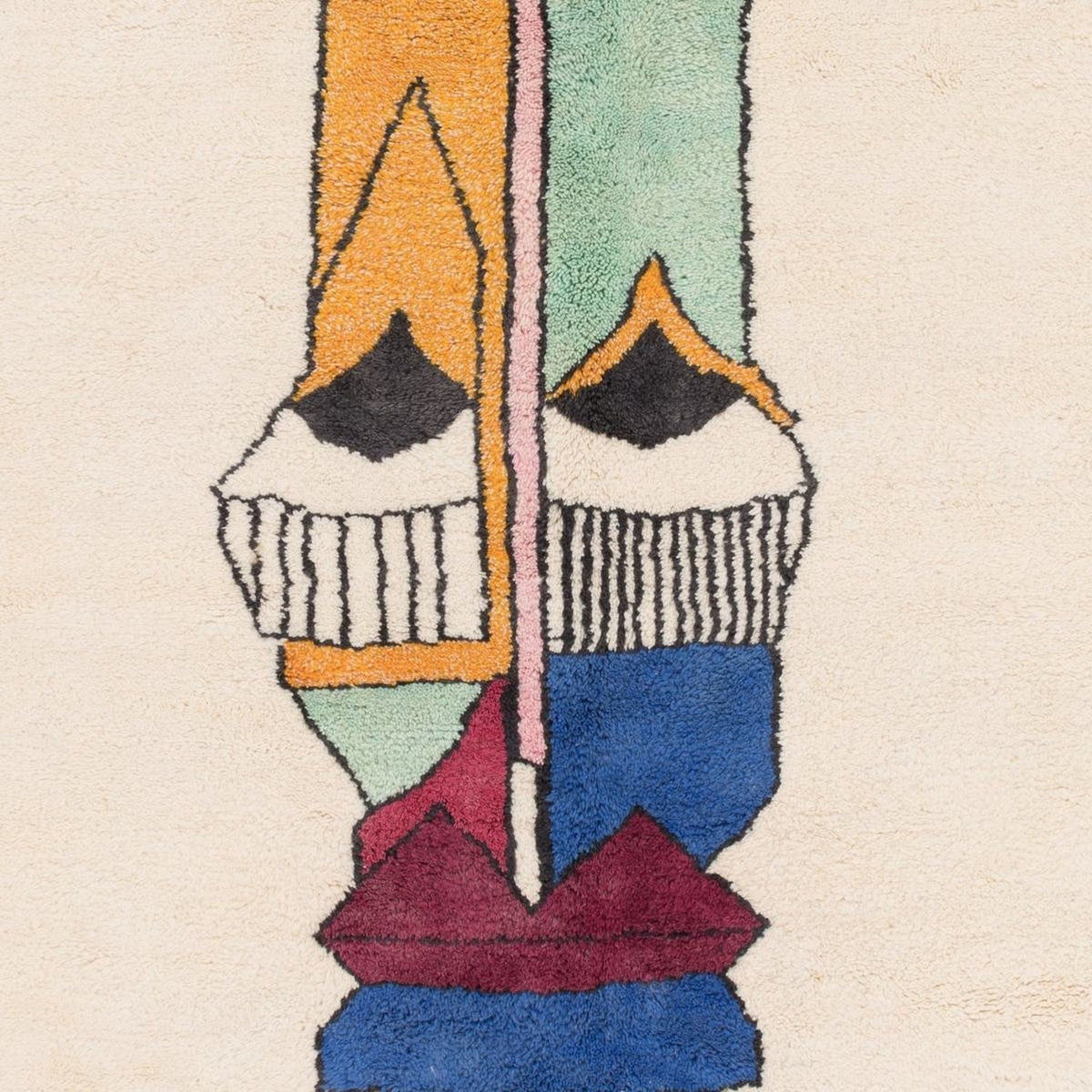 Detail of the artsy face rug with abstract design and colorful patterns.