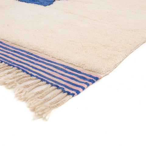 Close-up of the rug's fringe detail featuring a striped pattern.